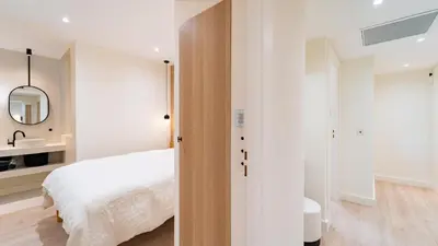 a bedroom with a white bed and a mirror at 3BDR Cocoon in Cannes Martinez avec Jardin Privé & Design Contemporain à 5 min de la Croisette in Cannes