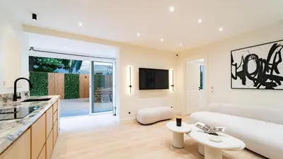 a kitchen and living room with a couch and a table at 3BDR Cocoon in Cannes Martinez avec Jardin Privé & Design Contemporain à 5 min de la Croisette in Cannes
