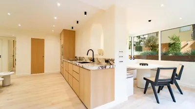 a kitchen with a counter and a table and chairs at 3BDR Cocoon in Cannes Martinez avec Jardin Privé & Design Contemporain à 5 min de la Croisette in Cannes