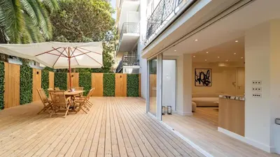 a patio with a table and an umbrella at 3BDR Cocoon in Cannes Martinez avec Jardin Privé & Design Contemporain à 5 min de la Croisette in Cannes