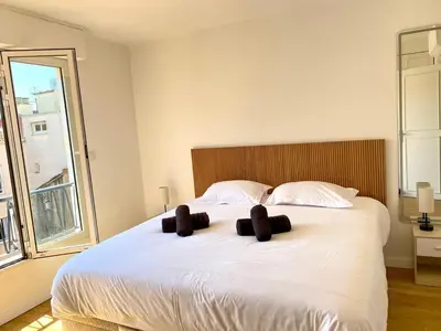 a bedroom with a large white bed with two brown pillows at Stylish Cannes Gem, Terrace, Parking, 100m to Croisette in Cannes
