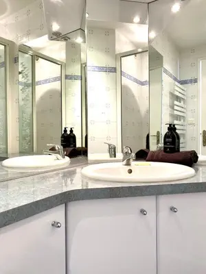 a bathroom with two sinks and two mirrors at Stylish Cannes Gem, Terrace, Parking, 100m to Croisette in Cannes