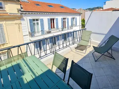 a patio with a green table and chairs on a balcony at Stylish Cannes Gem, Terrace, Parking, 100m to Croisette in Cannes
