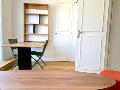 a room with a table and a book shelf and a door at Stylish Cannes Gem, Terrace, Parking, 100m to Croisette in Cannes