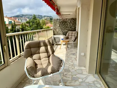 a patio with two chairs and a table on a balcony at Le Cirodde By SCLS Locations in Cannes