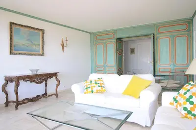 a living room with a white couch and a glass table at Vue unique sur toute la baie de Cannes et la mer in Cannes