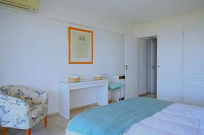 a bedroom with a bed and a desk and a chair at Vue unique sur toute la baie de Cannes et la mer in Cannes