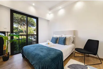 a bedroom with a bed and a chair and a window at apartment in Cannes-Croisette in Cannes