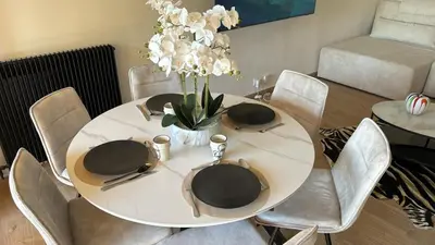 a white table with chairs and a white vase with flowers at apartment in Cannes-Croisette in Cannes