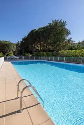 a blue swimming pool with a metal handrail in a resort at apartment in Cannes-Croisette in Cannes