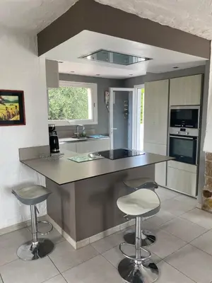 a kitchen with a counter and stools in it at Bastide Anna in Le Cannet
