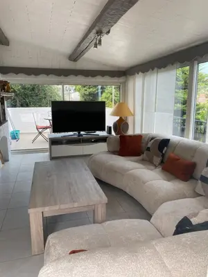 a living room with a couch and a flat screen tv at Bastide Anna in Le Cannet