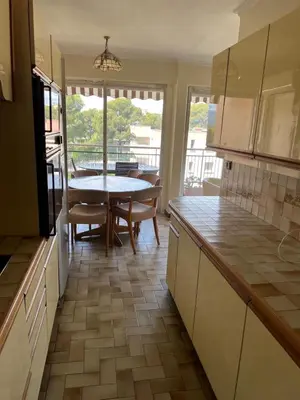 a kitchen with a table and a dining room at Le Cannet Rocheville grand 3 pieces 2 terrasses in Le Cannet