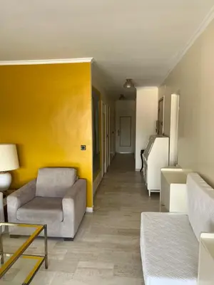 a living room with a couch and a yellow wall at Le Cannet Rocheville grand 3 pieces 2 terrasses in Le Cannet