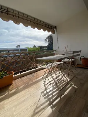 a room with a table and chairs on a balcony at Les Jades in Le Cannet