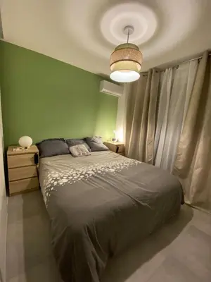 a bedroom with a bed with a green wall at Les Jades in Le Cannet