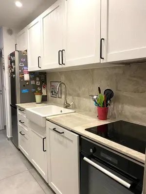 a kitchen with white cabinets and a sink at Les Jades in Le Cannet