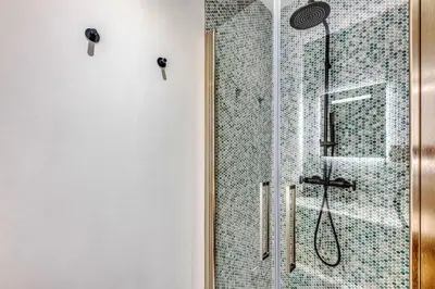 a bathroom with a shower with a glass door at Dune Croisette - Sea view in Cannes