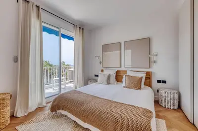 a bedroom with a large bed and a large window at Dune Croisette - Sea view in Cannes