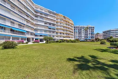 a large building with a grass field in front of it at Dune Croisette - Sea view in Cannes