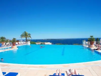 a large swimming pool with people laying in chairs in the water at Vue Mer, Piscine de ouf Votre Oasis à Cannes in Cannes