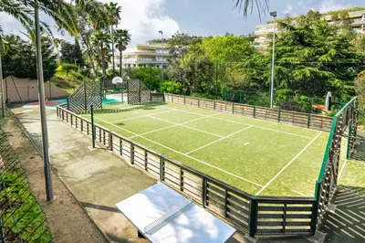 a tennis court with a net on a court at Vue Mer, Piscine de ouf Votre Oasis à Cannes in Cannes