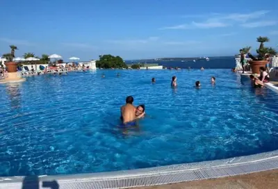 a group of people swimming in a large swimming pool at Vue Mer, Piscine de ouf Votre Oasis à Cannes in Cannes