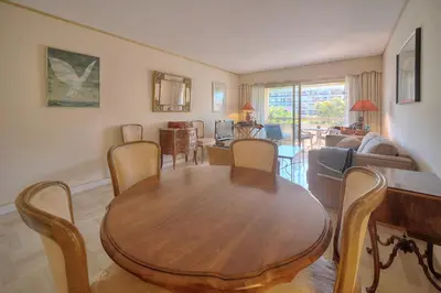 a living room with a wooden table and chairs at REF 1514 - Apartment with unobstructed view to rent in Cannes