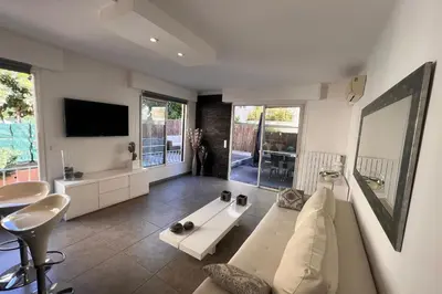 a living room with a white couch and a tv at REF 1921 - Cannes - Apartment for rent in Cannes