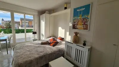 a bedroom with a bed and a table and a window at Appartement 2P Terrasse Cannes Croisette Beach 100 meters in Cannes