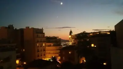 a view of a city at night with the moon at Appartement 2P Terrasse Cannes Croisette Beach 100 meters in Cannes