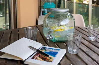 a wooden table with a book and a jar of food at Central T2 Cannes Suquet - terrasse - WIFI - Clim in Cannes
