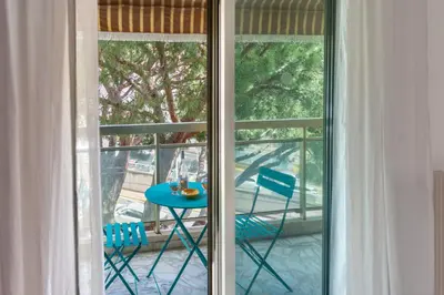 a bedroom with a white bed and a wall at Central T2 Cannes Suquet - terrasse - WIFI - Clim in Cannes