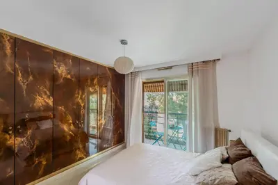 a room with a balcony with a table and chairs at Central T2 Cannes Suquet - terrasse - WIFI - Clim in Cannes