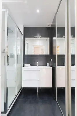a bathroom with a white sink and a mirror at Le Corail - SCLS Locations in Cannes