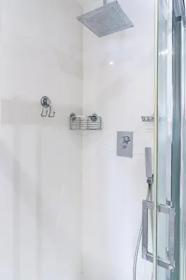 a bathroom with a shower with white tiles at Le Corail - SCLS Locations in Cannes