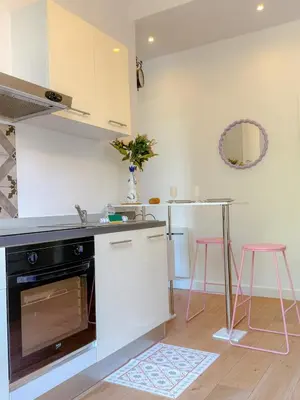 a kitchen with a sink and a counter with pink stools at Le Rosy By ApiRent #Balcon #Wifi #Centre-ville in Cannes