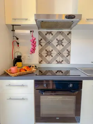 a kitchen with white cabinets and a stove top oven at Le Rosy By ApiRent #Balcon #Wifi #Centre-ville in Cannes