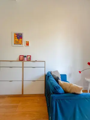 a living room with a blue couch and a dresser at Le Rosy By ApiRent #Balcon #Wifi #Centre-ville in Cannes