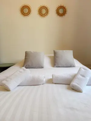 a white bed with two pillows and two mirrors on the wall at Le Rosy By ApiRent #Balcon #Wifi #Centre-ville in Cannes