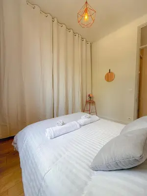 a bedroom with a large white bed with two towels at Le Rosy By ApiRent #Balcon #Wifi #Centre-ville in Cannes