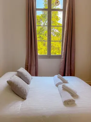 a bed with two towels on it with a window at Le Rosy By ApiRent #Balcon #Wifi #Centre-ville in Cannes