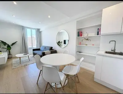 a kitchen and living room with a white table and chairs at Beautiful 2-room apartment on the Croisette in Cannes in Cannes