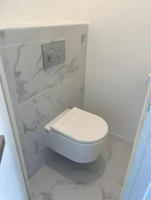 a white toilet in a bathroom with marble at Beautiful 2-room apartment on the Croisette in Cannes in Cannes