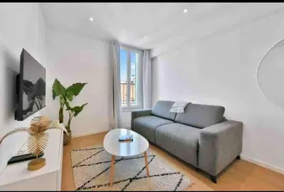 a living room with a couch and a table at Beautiful 2-room apartment on the Croisette in Cannes in Cannes