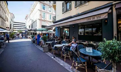 a group of people sitting at tables outside a cafe at Beautiful 2-room apartment on the Croisette in Cannes in Cannes