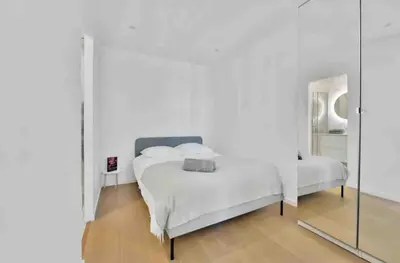 a white bedroom with a bed and a mirror at Cannes Croisette T2 new sublime in Cannes