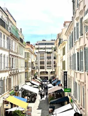 a city street with buildings and people walking down the street at Cannes Croisette T2 new sublime in Cannes