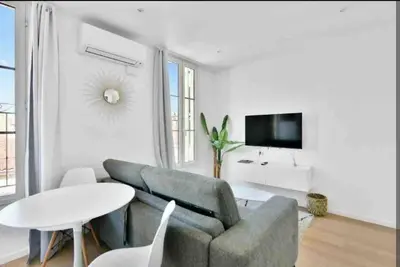 a living room with a couch and a table and a tv at Cannes Croisette T2 new sublime in Cannes