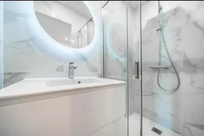 a white bathroom with a sink and a shower at Cannes Croisette T2 new sublime in Cannes